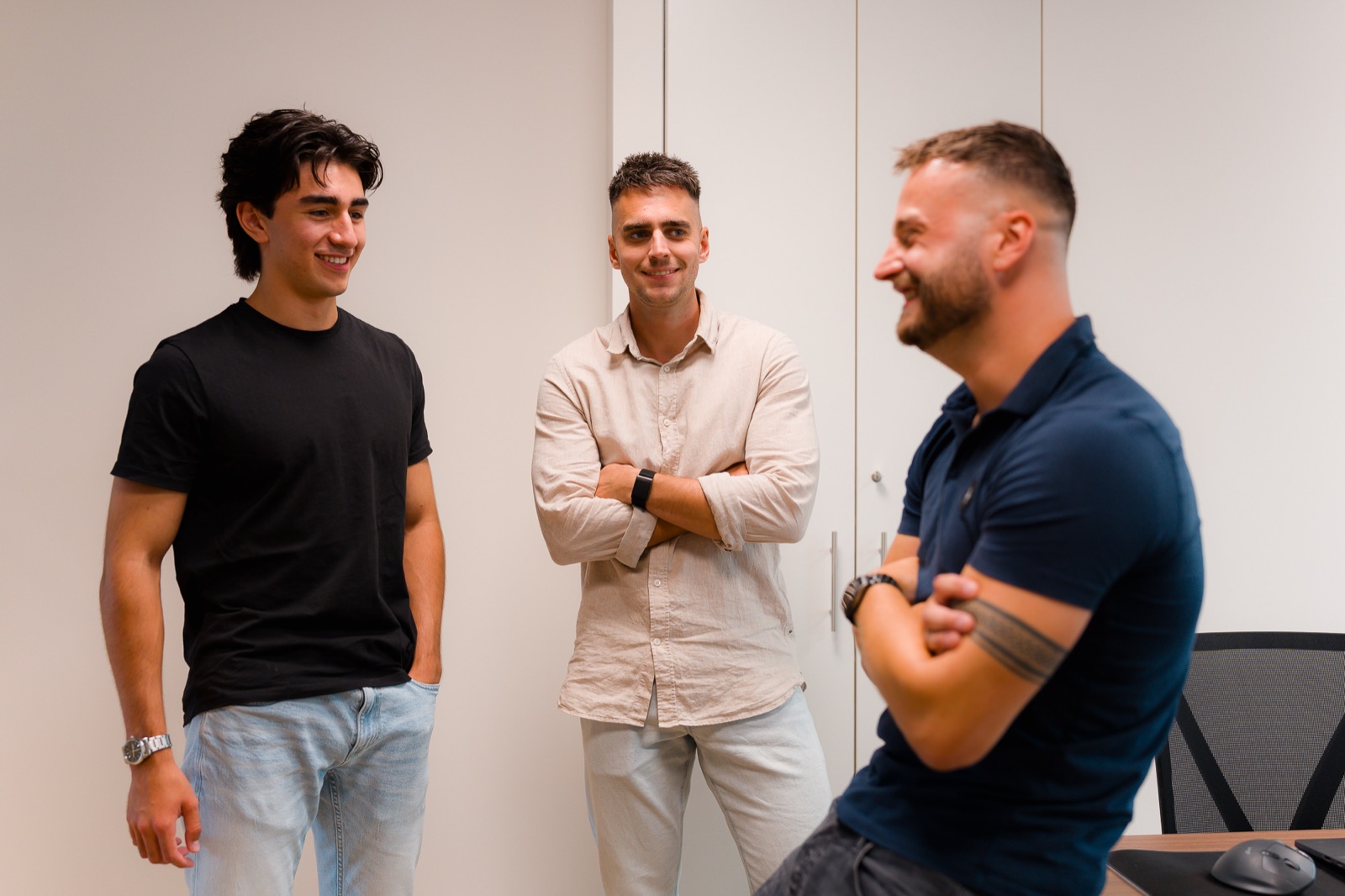 Drie collega's van Merkbouwer lachend in overleg